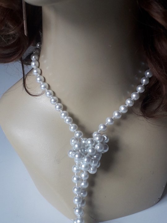 Halskæde i hvide fine perler. Hængende længde 62 cm. Kan vikles rundt 2-3 gange