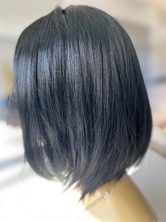 Paryk. Sort page med glat h&aring;r og pandeh&aring;r. Lidt mere l&aelig;ngde