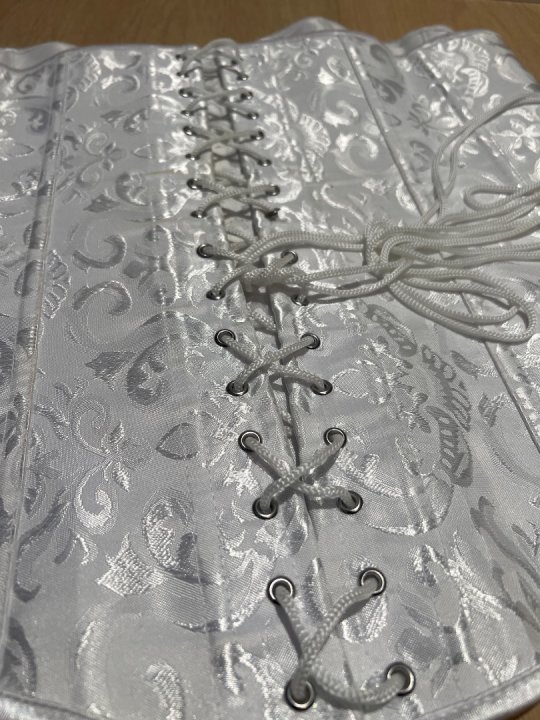 Corset i hvid Brogade med h&aelig;gter foran og sn&oslash;rer  p&aring; ryg. Taljem&aring;l: 90-110cm