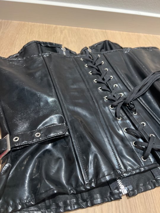 Lak corset i str&aelig;k med lynl&aring;s foran og sn&oslash;rre p&aring; ryg. Str. 48/50