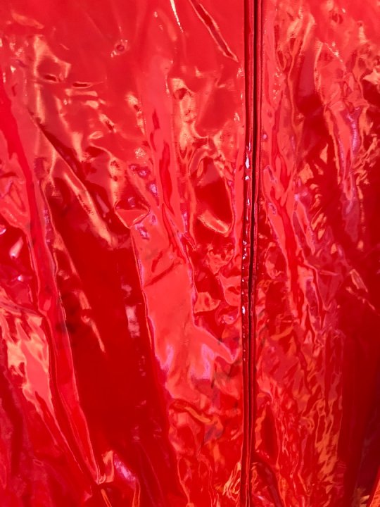 Heldragt i r&oslash;d lak med lynl&aring;s foran og op bagp&aring;. Taljem&aring;l 85-105 cm