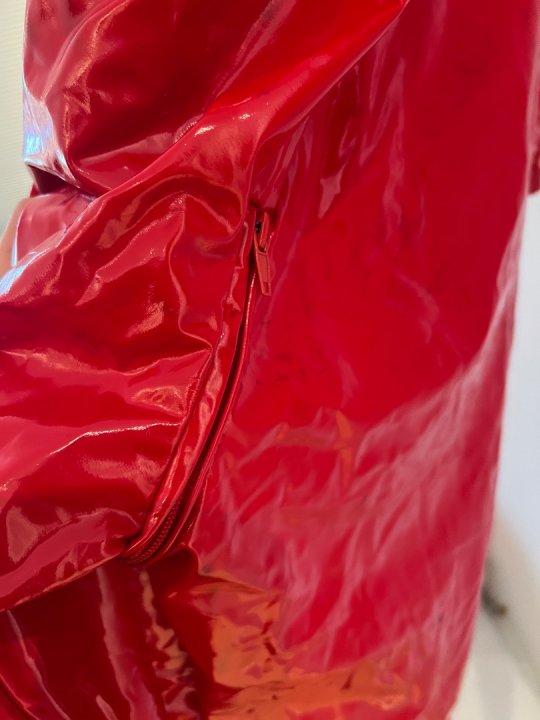 Heldragt i r&oslash;d lak med lynl&aring;s foran og op bagp&aring;. Taljem&aring;l 85-105 cm