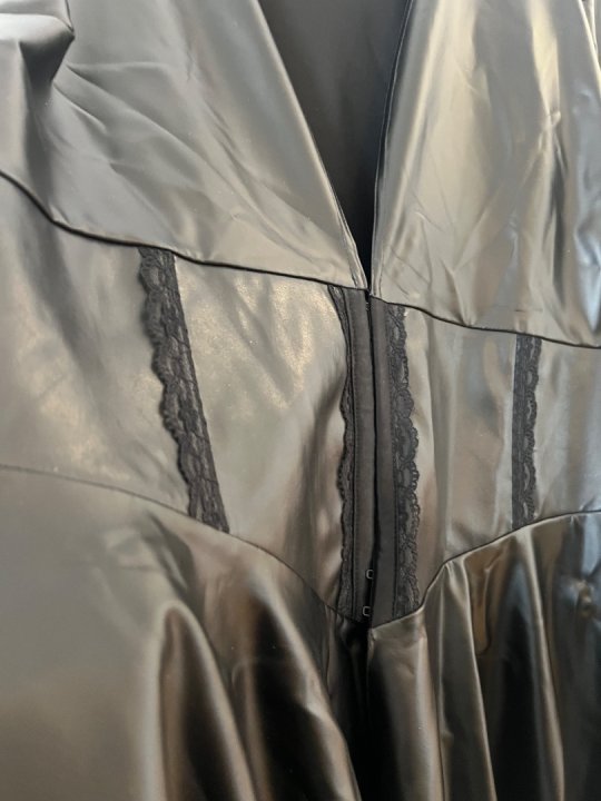 Kjole i sort og l&aelig;kker l&aelig;derlook. Dyb udsk&aelig;ring. Str. 52. Brystm&aring;l: 105-140 cm